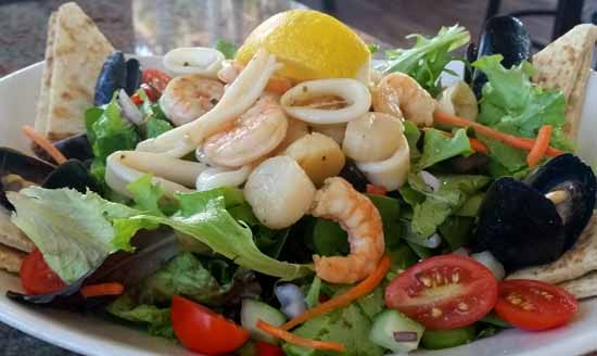 Island Salad with tomatoes, shrimp, stringed carrot and pita bread
